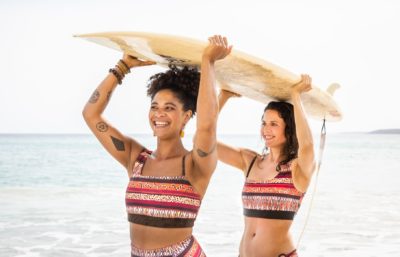 Zwei Frauen mit einem Surfbrett